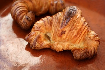 Two croissant pastries over orange clay