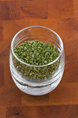 dried chive in glass on wooden table