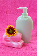 liquid soap, flower and towel on pink