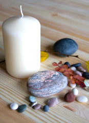 Fototapeta premium White Candle and Many-Coloured Stones