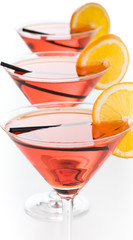 Drei rote Cocktails mit Orange und Strohhalm