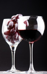 a glass of red wine and grape