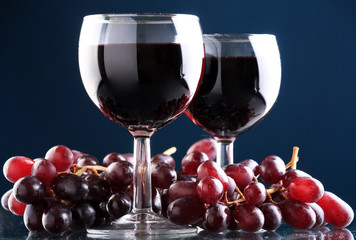 a glass of red wine and grape