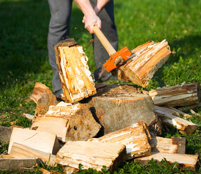 Hands Of A Strong Man Splitting Wood With An Axe