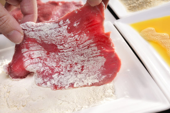 Fleisch in Mehl wenden