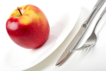 Utensils and red apple