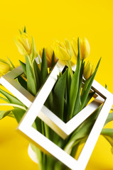 Bunch of yellow tulip flowers with silver photo frame