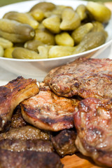 Grilled pork meat and pickled cucumbers