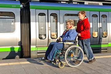 Junge schiebt Frau im Rollstuhl
