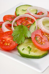 Tomaten-Gurkensalat auf einem weißen Teller