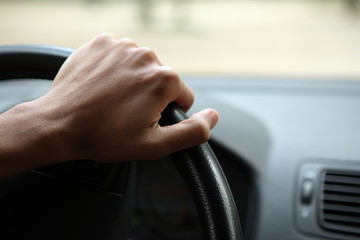 Fototapeta na wymiar Close-up z męskiej dłoni na kierownicy w nowoczesnym samochodzie