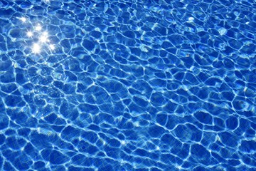 Blue water texture, tiles pool in sunny day