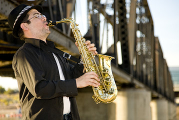 A saxophonist plays in an industrial setting