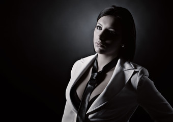 Obraz premium Low Key Shot of an Attractive Brunette in White Suit and Tie