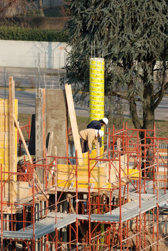 Ponteggio con muratori al lavoro in un cantiere edile