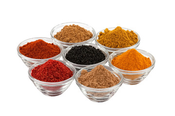 several indian spices in glass bowls