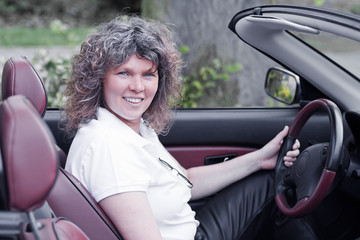 Woman steering a cabriolet
