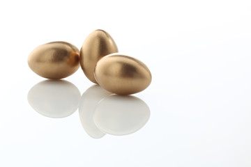 drei goldene Eier auf weissem Acryl