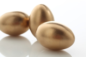 drei goldene Eier auf weissem Acryl