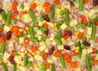 Pizza ingredients cheese, ham, basil, corn and vegetables