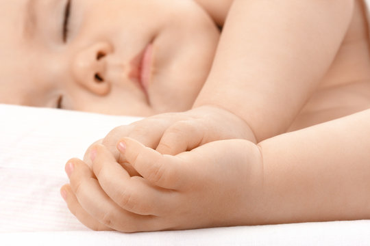 Caucasian child asleep, clasping hands together