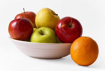 Apples on a plate and an orange