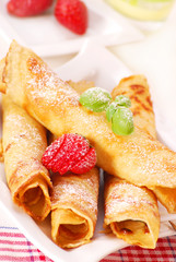 rolled pancakes with powder sugar and  strawberry