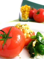 Tomato Stuffed with corn and mayonnaise on white dish