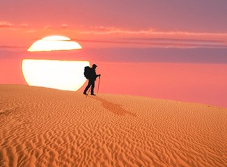 Fototapeta na wymiar alone traveler is in the desert at the evening
