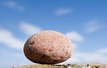 Fototapeta na wymiar round stone on a background sky
