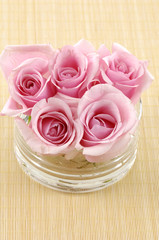 Pink rose flowers floating in a bowl with water