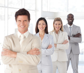 Business man with arms folded in front of Business Team