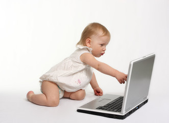little girl touching screen on the laptop