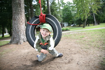Young boy playing in tire swing