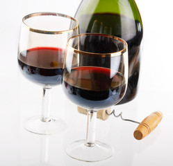 Glass of red wine with glass and bottle