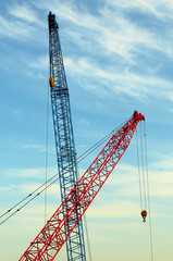 two construction cranes over blue sky