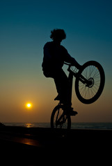 Obraz na płótnie Canvas Młody mężczyzna wykonując sztuczki rowerów