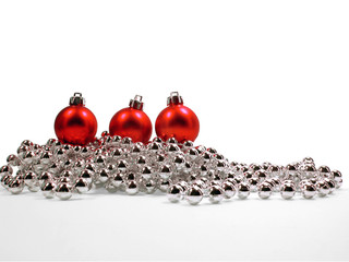 Three red Christmas ornaments on a silver chain