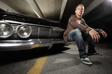 Young urban man with his lowrider car