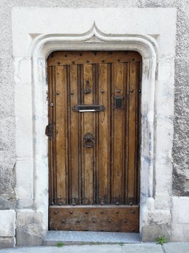 Old wooden door with medieval carved stone lintel