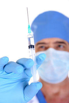 male surgeon holding syringe with vaccine