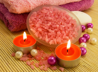Salt with rose oil, candle and bamboo towels for relaxation