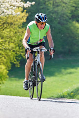 Fototapeta na wymiar Aktiver Senior fährt Fahrrad für Fitness