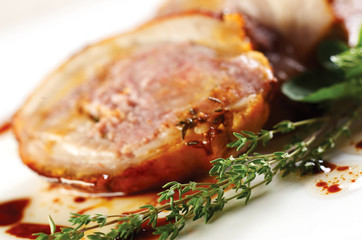 Detail of thyme herb in front of baked pork meat