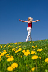 young woman in red outfit having fun on meadow