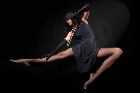 dancing girl with in hat with veil against black background