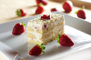 Tiramisu cake with strawberry on white plate