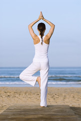 Fototapeta na wymiar Frau macht Yoga am Strand