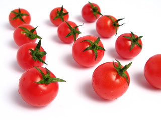 Cherry tomatoes forming lines on white background