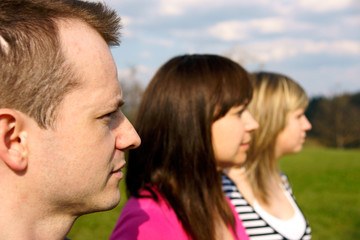 Fototapeta premium One male two woman profile view in a row smiling